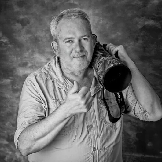 Photographer preparing camera gear in the African bush