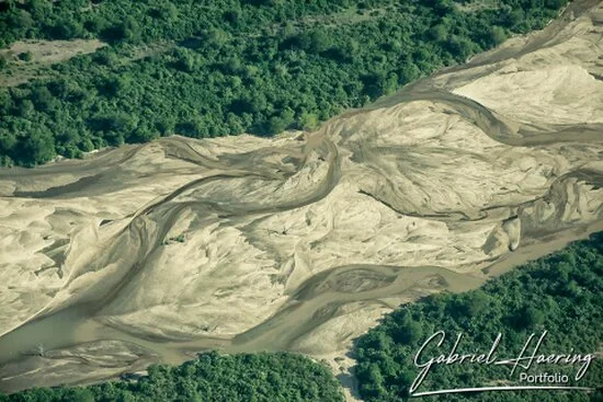 Aerial view of pale sandbanks and winding river channels in Nyerere National Park, Tanzania.